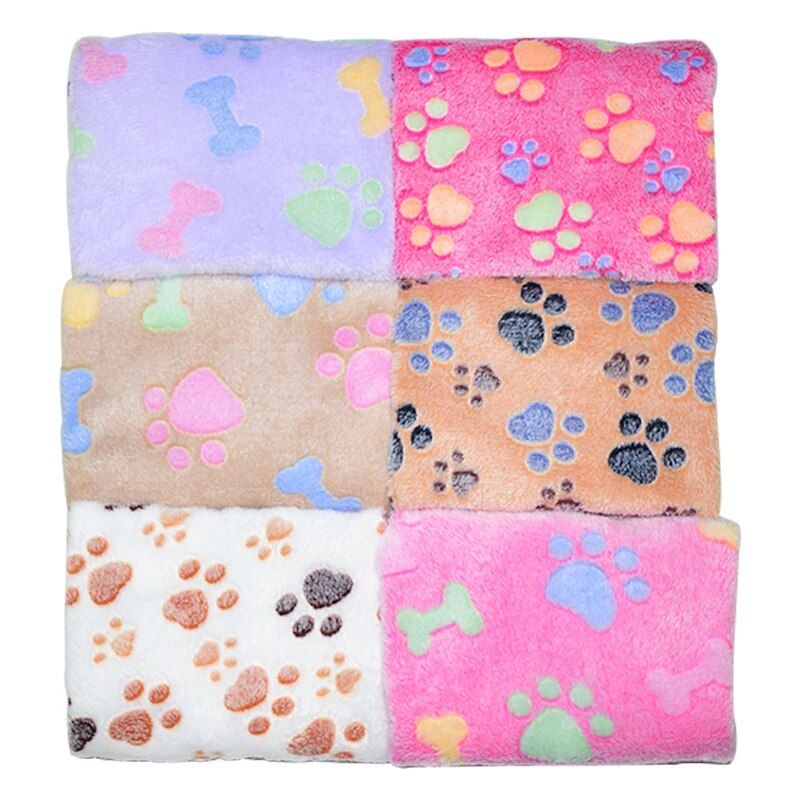 A collection of six 11395-328fc4.jpg in different colors and patterns, each featuring paw prints and bones. These cozy blankets come in pink, purple, beige, brown, and white styles.